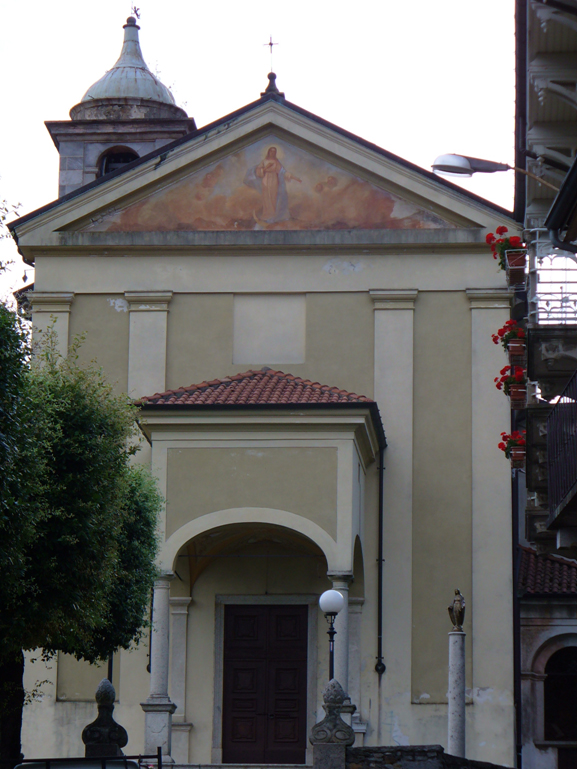 Chiesa parrocchiale con campanile a cupola e portale con tetto in tegole a protezione della porta di ingresso