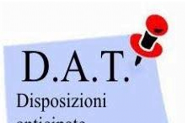 Su un foglio puntato da una spilla rossa e nera la scritta "D.A.T. Disposizioni Anticipate di Trattamento"