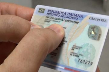 Una mano tiene una Carta d'Identità Elettronica.
