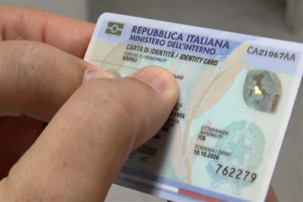 Una mano tiene una Carta d'Identità Elettronica.