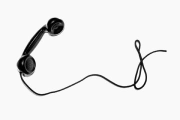 Una cornetta telefonica nera in campo bianco.