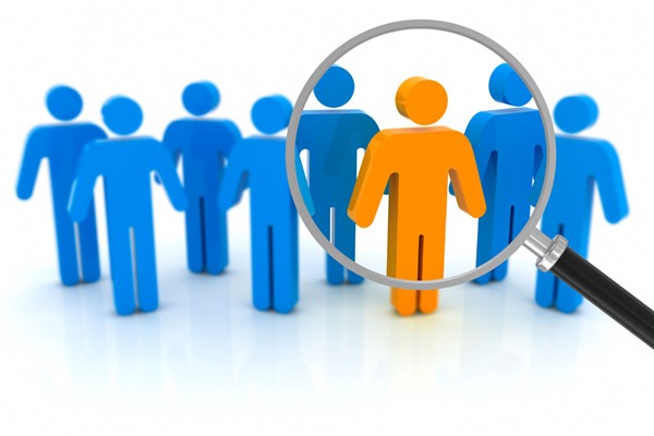 Su fondo bianco sette figure umane stilizzate di colore blu e al centro una figura umana stilizzata di colore arancione, evidenziata da una lente di ingrandimento.