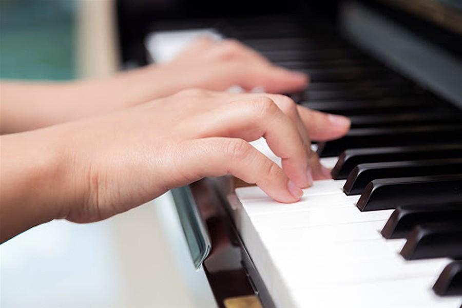 Due mani che suonano un pianoforte.
